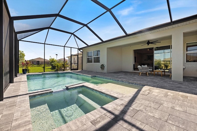 view of pool featuring a patio area, glass enclosure, a pool with connected hot tub, and ceiling fan