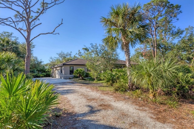 view of front of house with stucco siding, an attached garage, and driveway