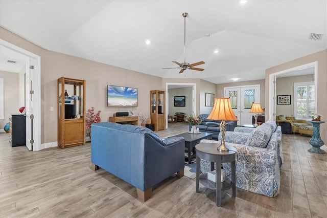 living room with lofted ceiling, visible vents, light wood finished floors, and ceiling fan