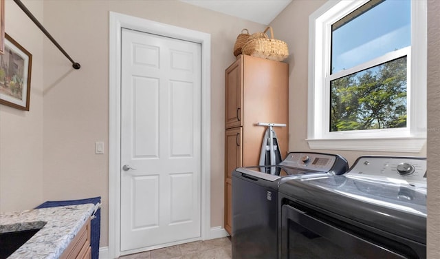 laundry area featuring separate washer and dryer, cabinet space, and baseboards