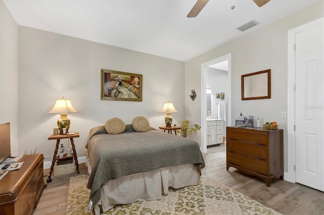 bedroom featuring visible vents, baseboards, light wood-style flooring, and ensuite bathroom