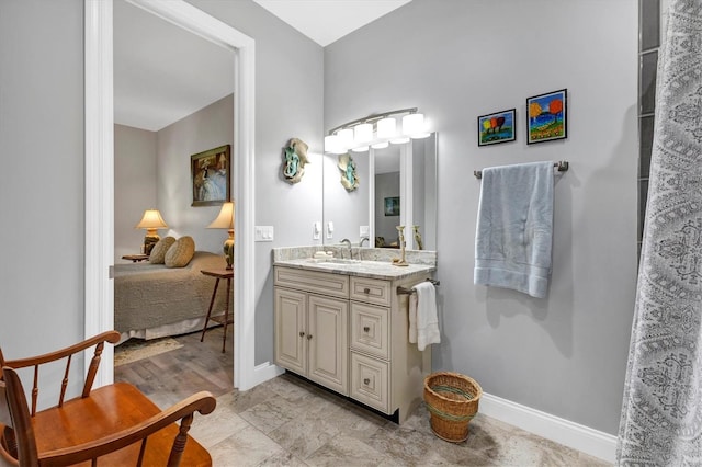 full bathroom with ensuite bath, vanity, and baseboards