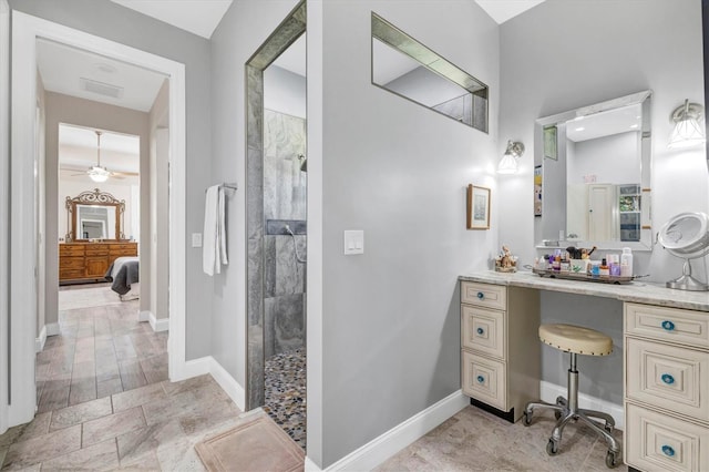 ensuite bathroom featuring visible vents, a walk in shower, ceiling fan, baseboards, and vanity