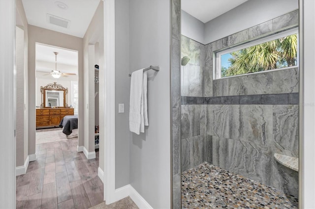 ensuite bathroom with a ceiling fan, a walk in shower, wood finished floors, ensuite bath, and baseboards