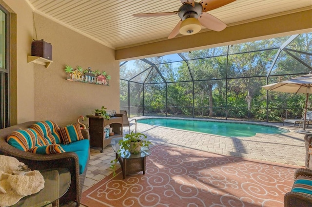 pool with a lanai, a patio area, and ceiling fan