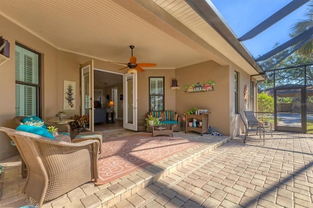 view of patio with glass enclosure and ceiling fan