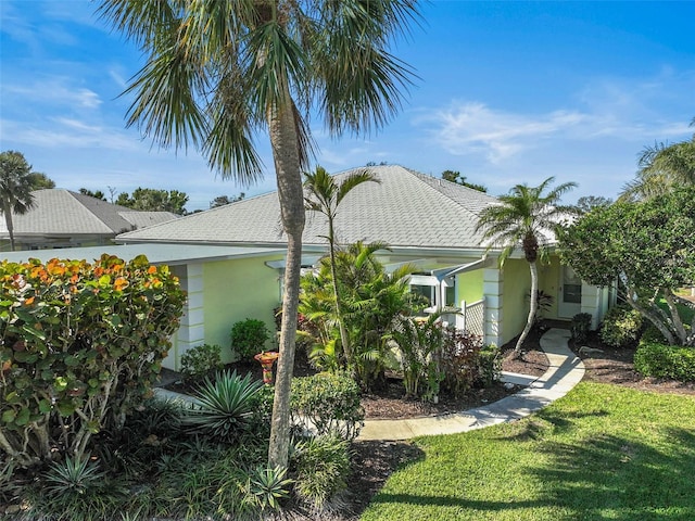 view of property exterior featuring roof with shingles and a lawn