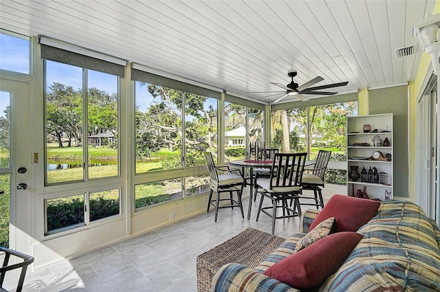 sunroom featuring visible vents, a ceiling fan, wood ceiling, and a healthy amount of sunlight