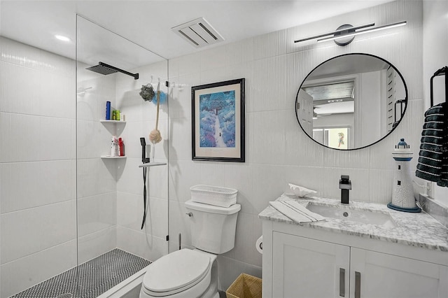 full bathroom featuring a walk in shower, visible vents, toilet, and tile walls