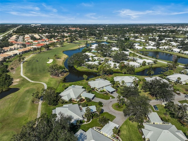 drone / aerial view featuring a residential view, view of golf course, and a water view