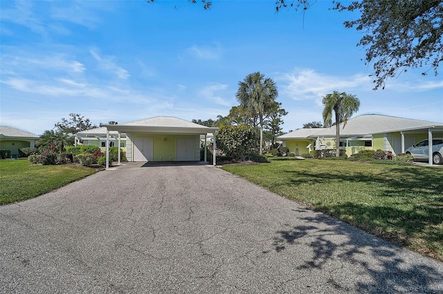 view of front facade with driveway, a carport, and a front yard