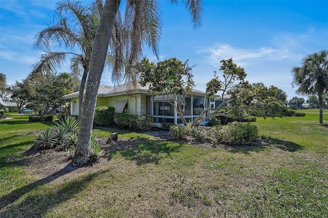 view of property exterior with a yard and a sunroom