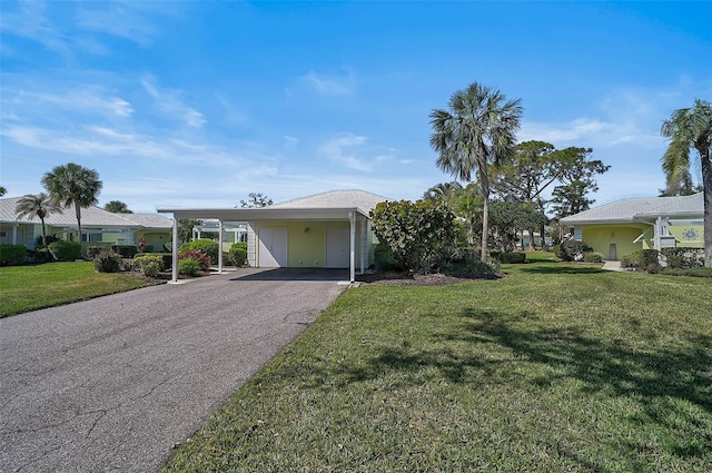 view of front of property with a carport, a front lawn, and driveway