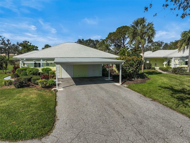 view of front of property featuring a carport, driveway, and a front lawn