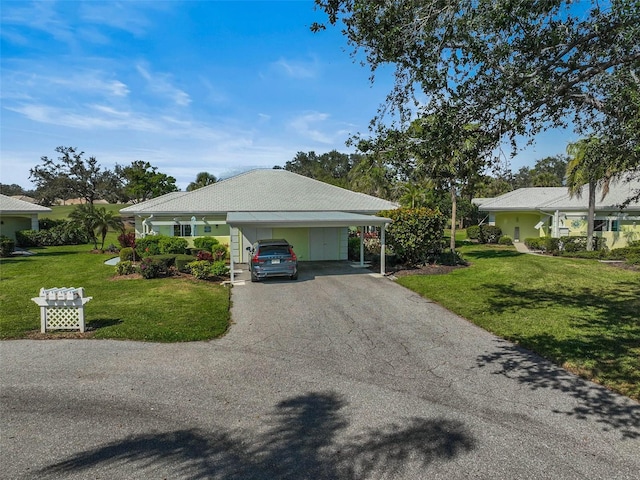 view of side of home featuring aphalt driveway, a lawn, and a carport