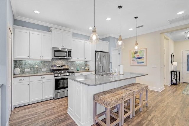 kitchen with a breakfast bar, light wood-type flooring, stainless steel appliances, and a sink