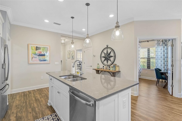 kitchen featuring dark wood-style floors, appliances with stainless steel finishes, a sink, and crown molding