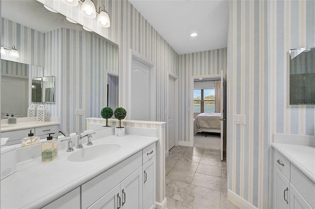 bathroom with connected bathroom, recessed lighting, vanity, baseboards, and wallpapered walls