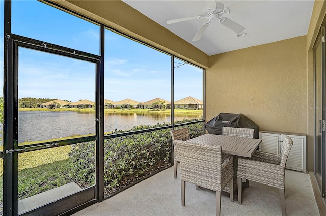 sunroom with a water view and ceiling fan