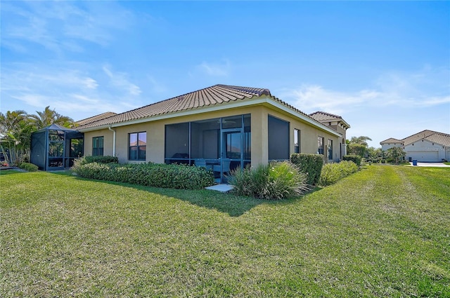 view of home's exterior featuring glass enclosure, a tile roof, a lawn, and stucco siding