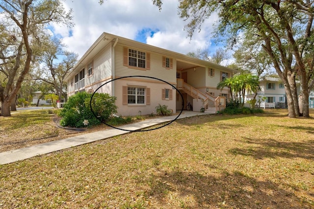 view of front of home with stairway and a front yard