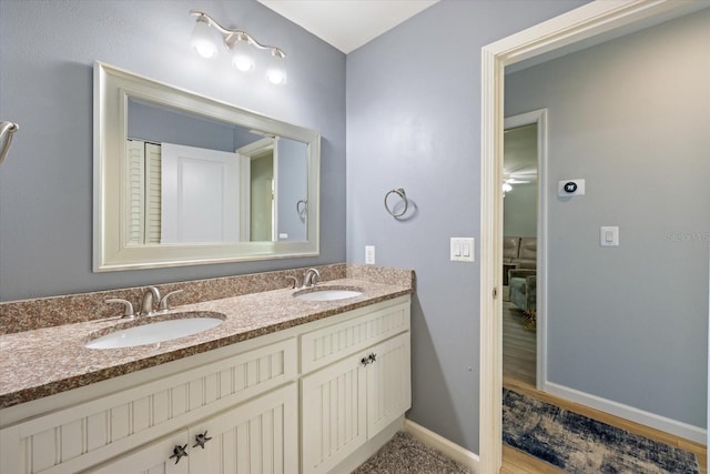 929 The Rialto, Venice, FL 34285 - full bathroom with a sink, baseboards, and double vanity