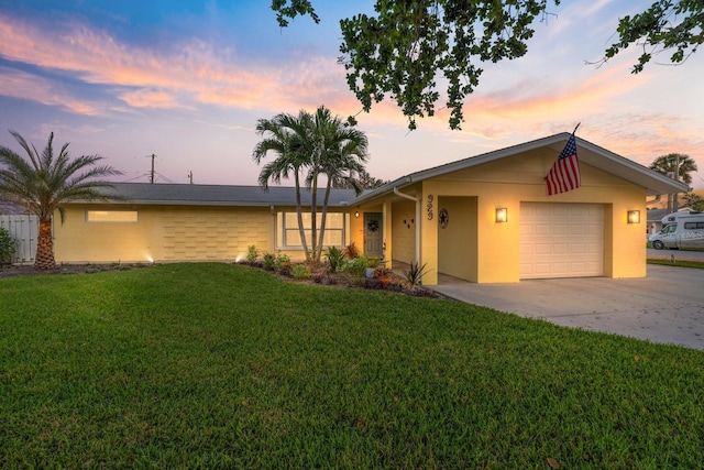 single story home featuring driveway, a lawn, an attached garage, and stucco siding