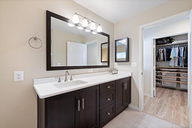 929 The Rialto, Venice, FL 34285 - bathroom featuring baseboards, a walk in closet, and vanity
