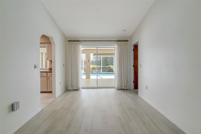 5875 Jackson, Venice, FL 34293 - empty room featuring light wood-style floors, baseboards, and arched walkways