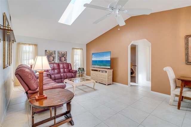 5875 Jackson, Venice, FL 34293 - living room with arched walkways, ceiling fan, light tile patterned flooring, baseboards, and lofted ceiling with skylight