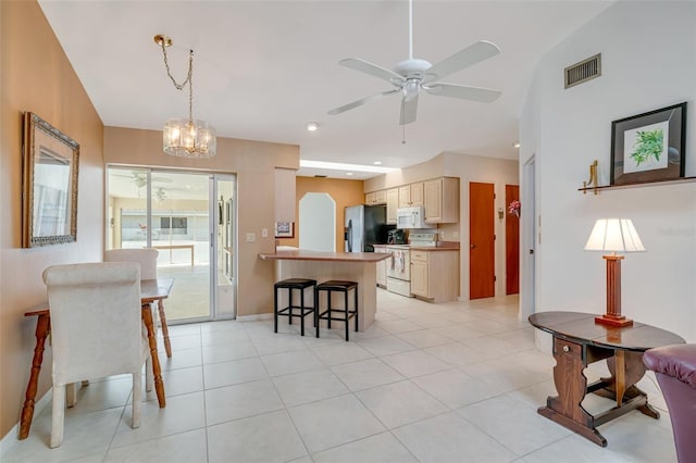 5875 Jackson, Venice, FL 34293 - kitchen featuring white appliances, visible vents, ceiling fan, a breakfast bar, and light brown cabinetry
