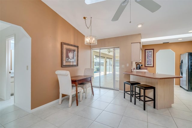 5875 Jackson, Venice, FL 34293 - dining area with a ceiling fan, vaulted ceiling, baseboards, and light tile patterned floors