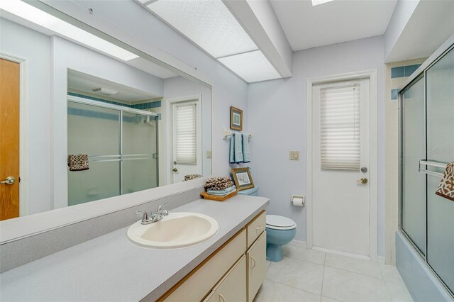 5875 Jackson, Venice, FL 34293 - bathroom featuring toilet, combined bath / shower with glass door, vanity, baseboards, and tile patterned floors