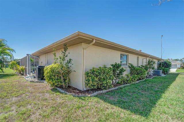 5875 Jackson, Venice, FL 34293 - view of home's exterior with cooling unit, a yard, and stucco siding