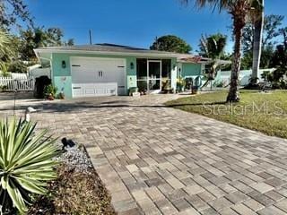 single story home with decorative driveway, fence, and an attached garage