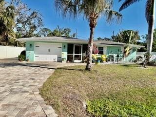 single story home featuring a garage, driveway, a front yard, and fence