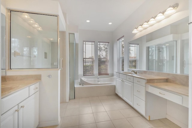 full bath featuring two vanities, tile patterned flooring, a sink, and a bath