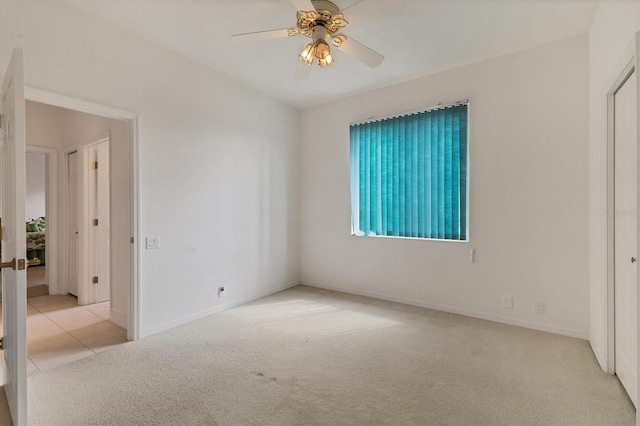 carpeted spare room featuring baseboards, a ceiling fan, and french doors