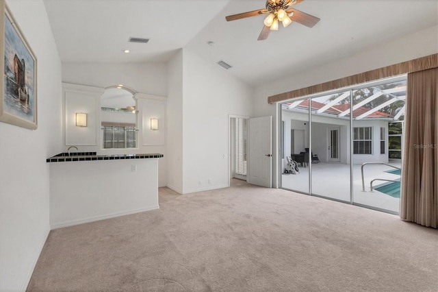 unfurnished living room with light carpet, high vaulted ceiling, ceiling fan, and visible vents