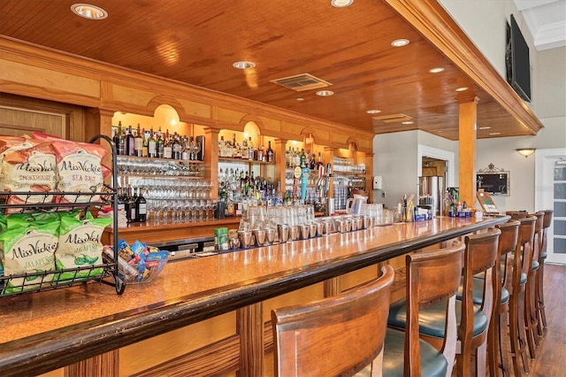 bar with wooden ceiling, visible vents, crown molding, and wood finished floors