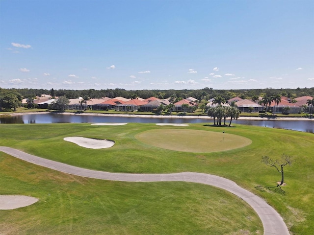view of community with a water view, a lawn, and golf course view