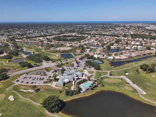 drone / aerial view featuring a residential view, view of golf course, and a water view