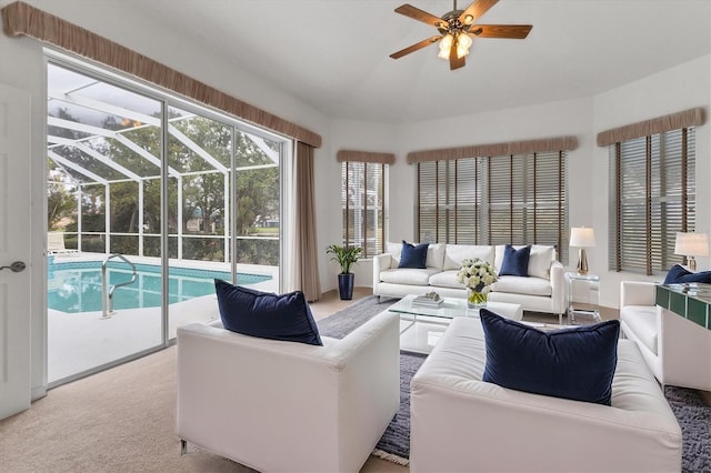 carpeted living room with a sunroom and a ceiling fan