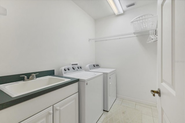 laundry room featuring visible vents, light tile patterned flooring, a sink, washer and dryer, and baseboards