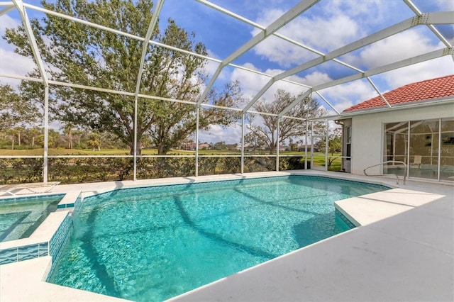 view of pool featuring glass enclosure, a patio area, and a pool with connected hot tub