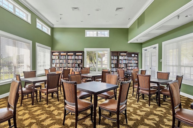 dining area featuring ornamental molding, visible vents, and plenty of natural light