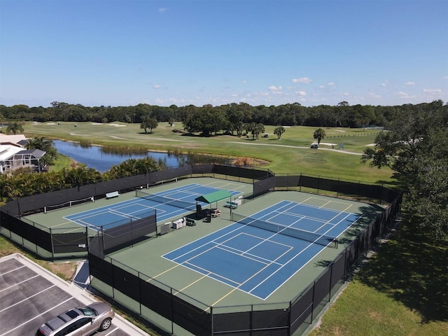 view of tennis court featuring a water view, fence, and golf course view