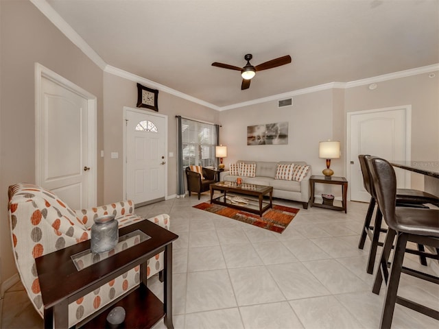 living room with ornamental molding, a ceiling fan, visible vents, and light tile patterned floors