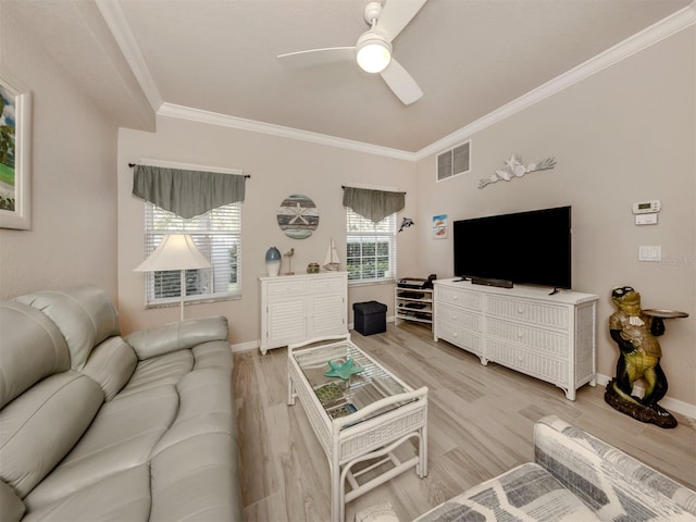 living area with visible vents, baseboards, light wood-style flooring, ceiling fan, and ornamental molding