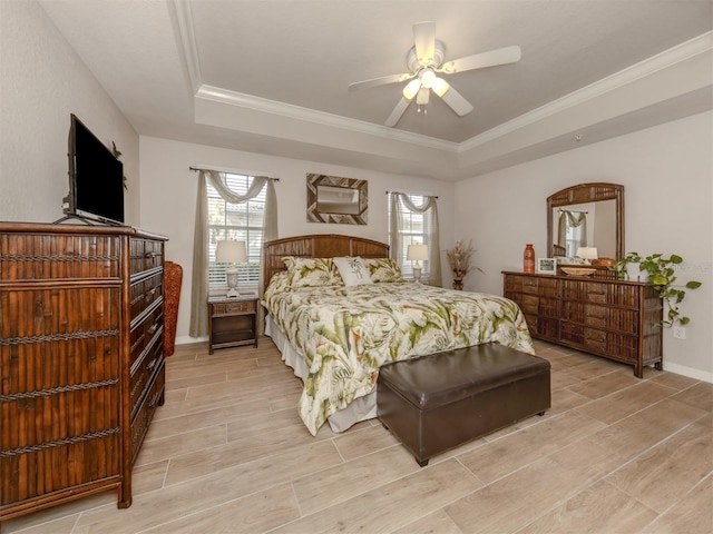 bedroom featuring ornamental molding, a tray ceiling, and wood finish floors